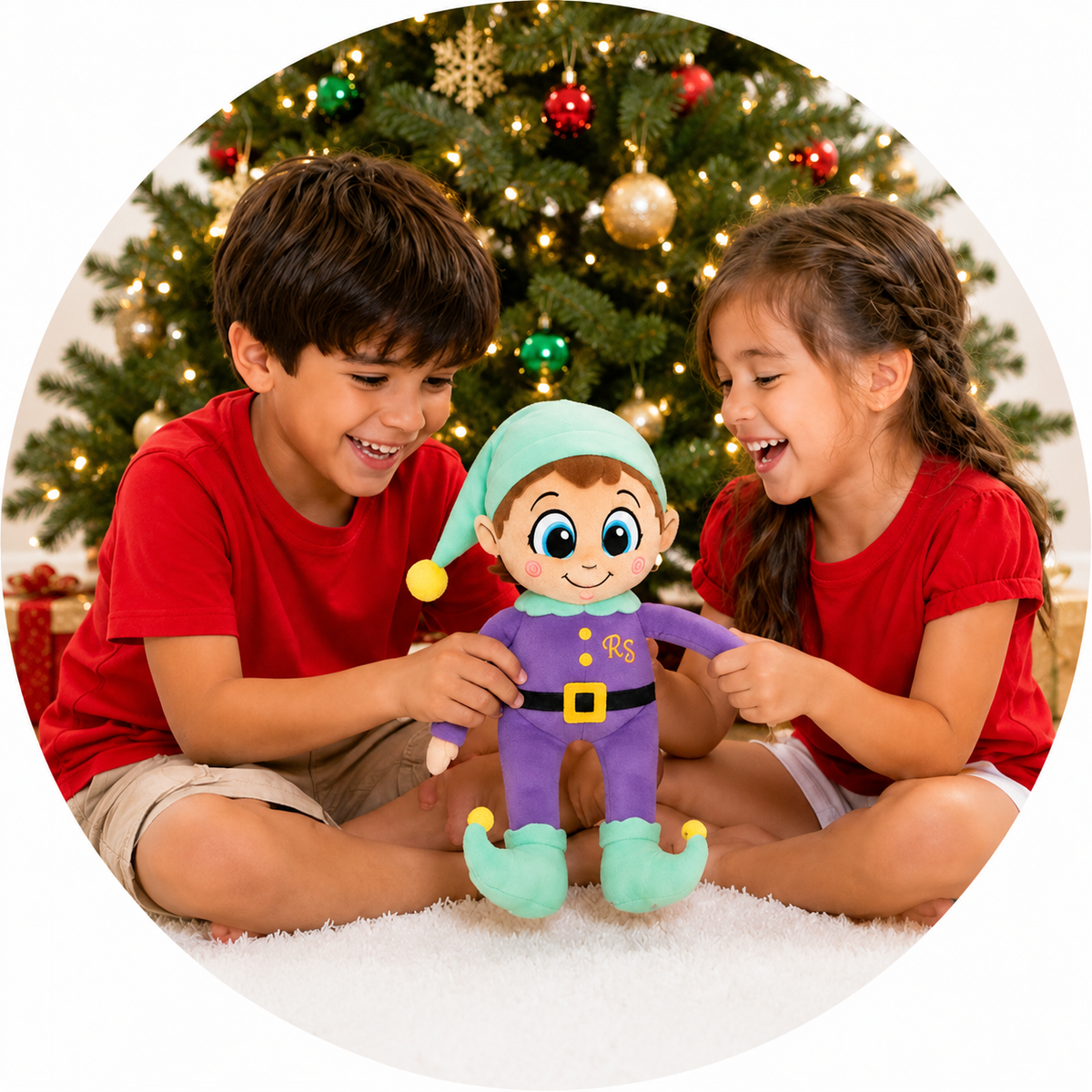Two children smiling with a Rhymin’ Simon plush near a Christmas tree
